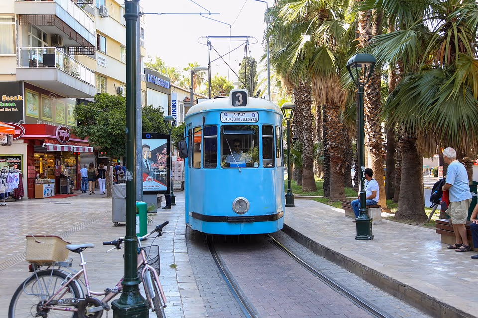 Blauwe nostalgische tram in een winkelstraat met palmen in het centrum van Antalya