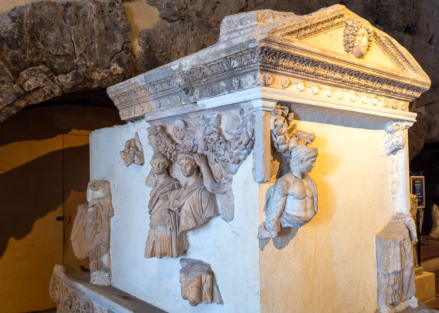 Stenen sarcofaag waarvan de wanden rondom met figuren zijn bewerkt, tentoongesteld in Antalya
