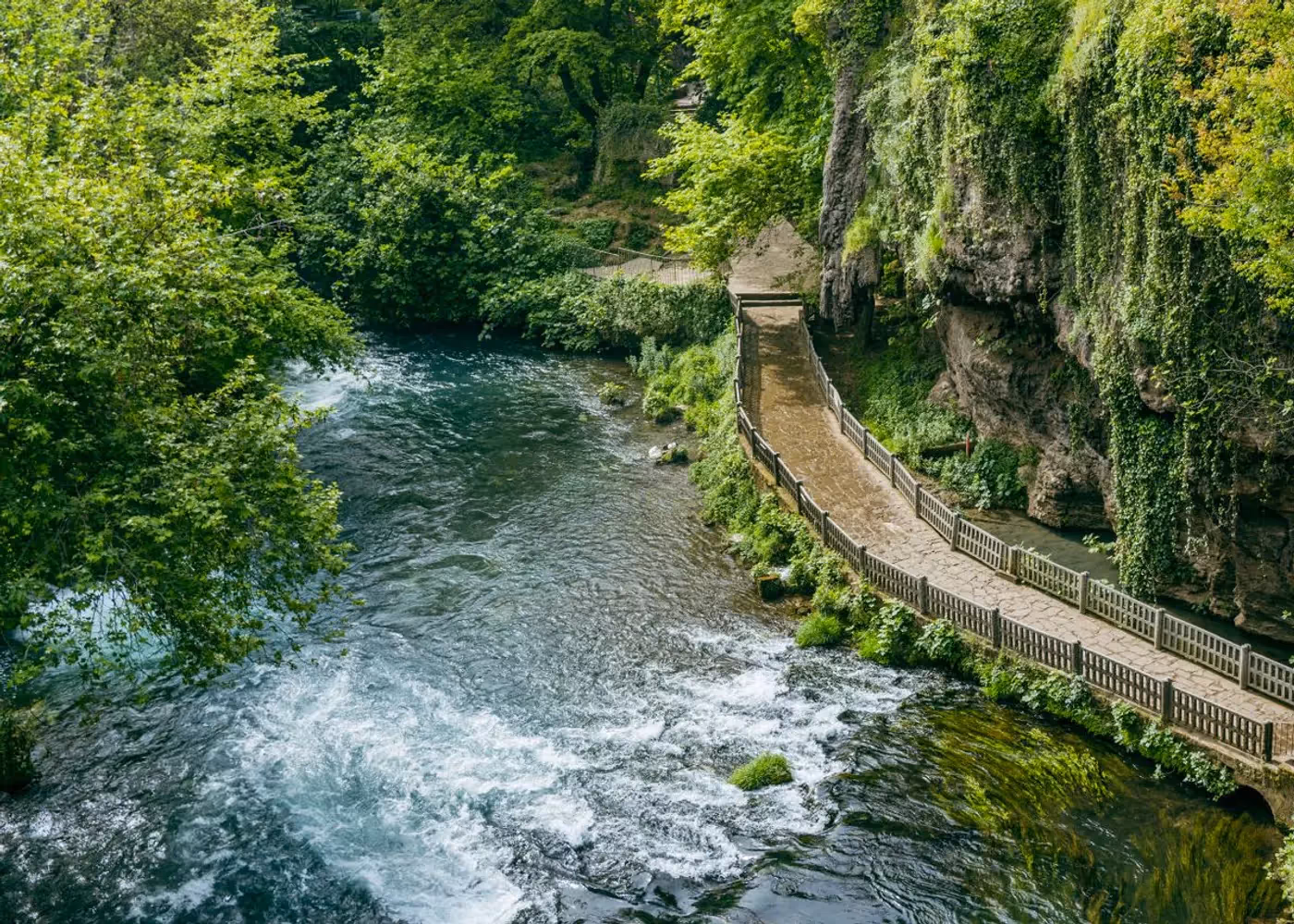 Bruisende rivier met een voetpad ernaast in het watervalpark Yukarı Düden in Kepez