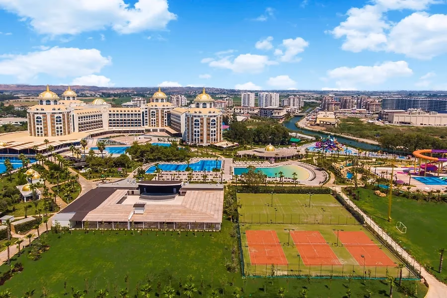 Delphin Be Grand Resort van boven, met de gebouwen met gouden koepels, de zwembaden, de tennisbanen en de rivier