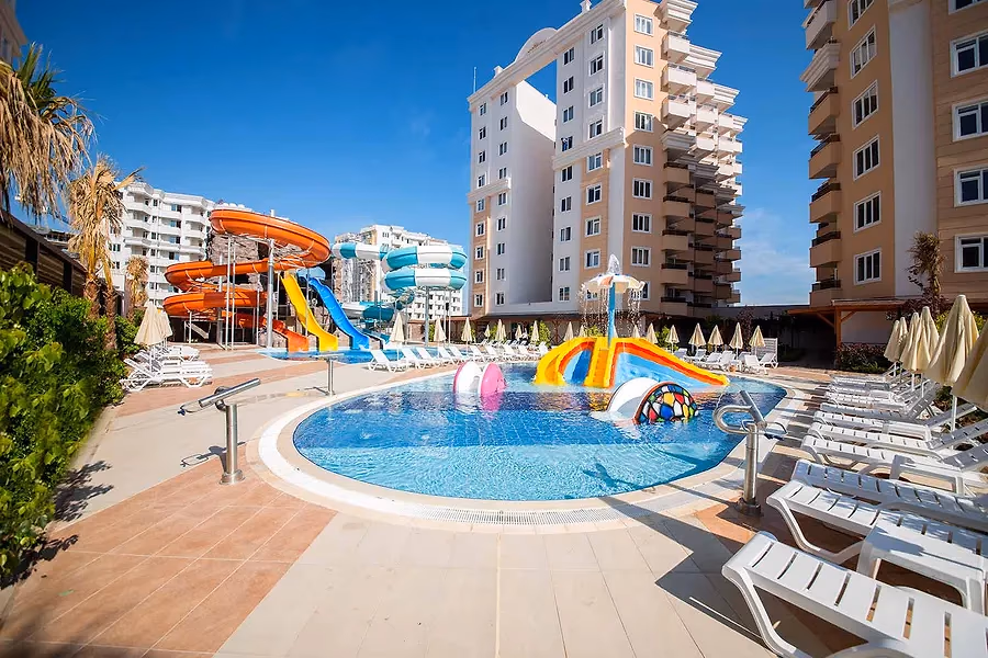 Hoge hotelgebouwen van Ramada Resort Lara met een zwembad en glijbanen op de voorgrond
