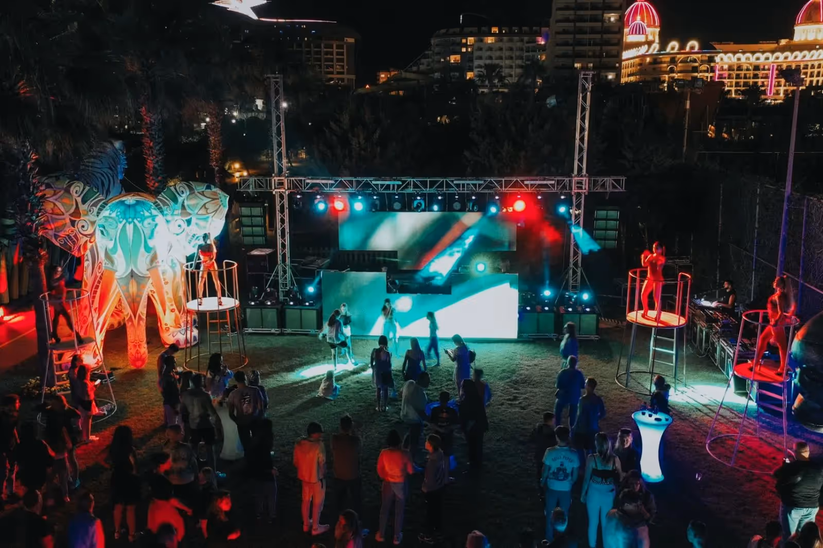 Avondfeest op het buitenpodium met lichtshow en dansende gasten bij Saturn Palace Resort in Lara