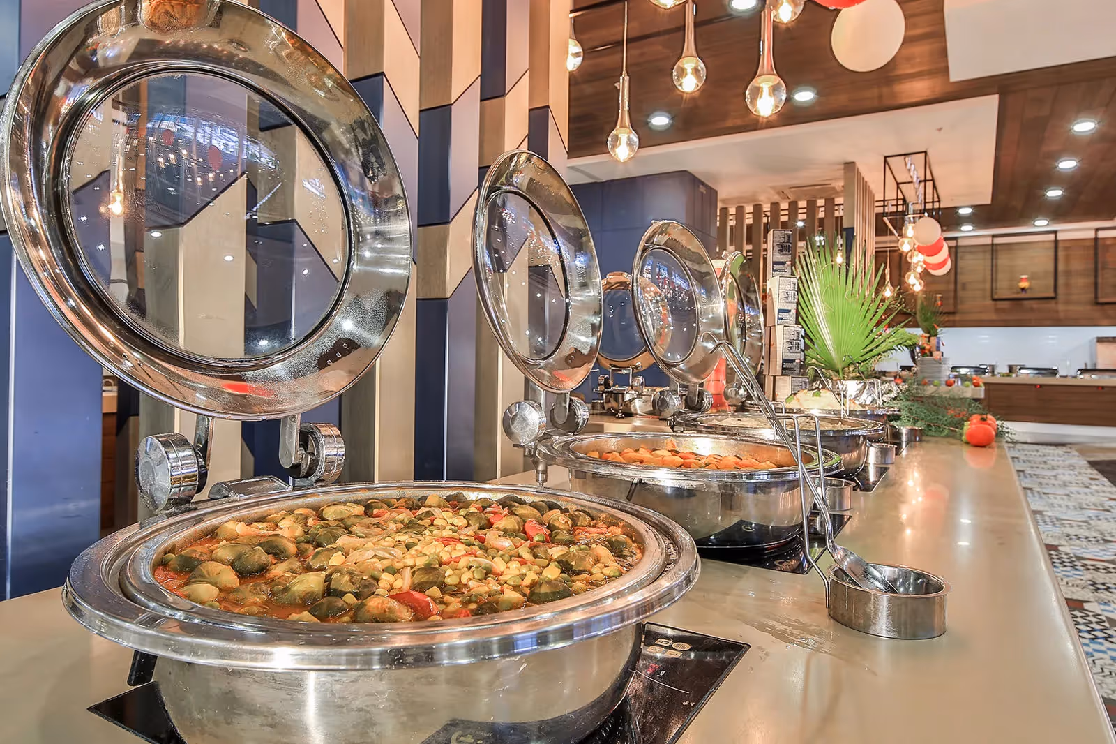 Warme gerechten in glanzende schalen met deksels aan het buffet in Saturn Palace Resort in Lara