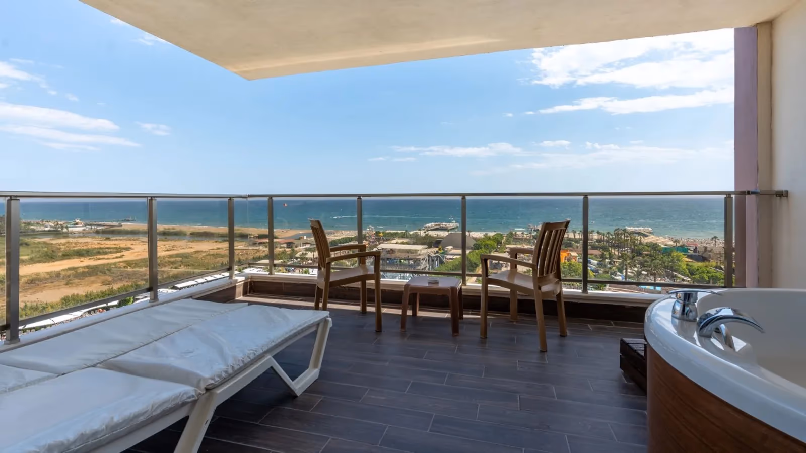 Ruim terras met ligbed, whirlpool en tafel met stoelen en uitzicht over zee bij Saturn Palace Resort in Lara