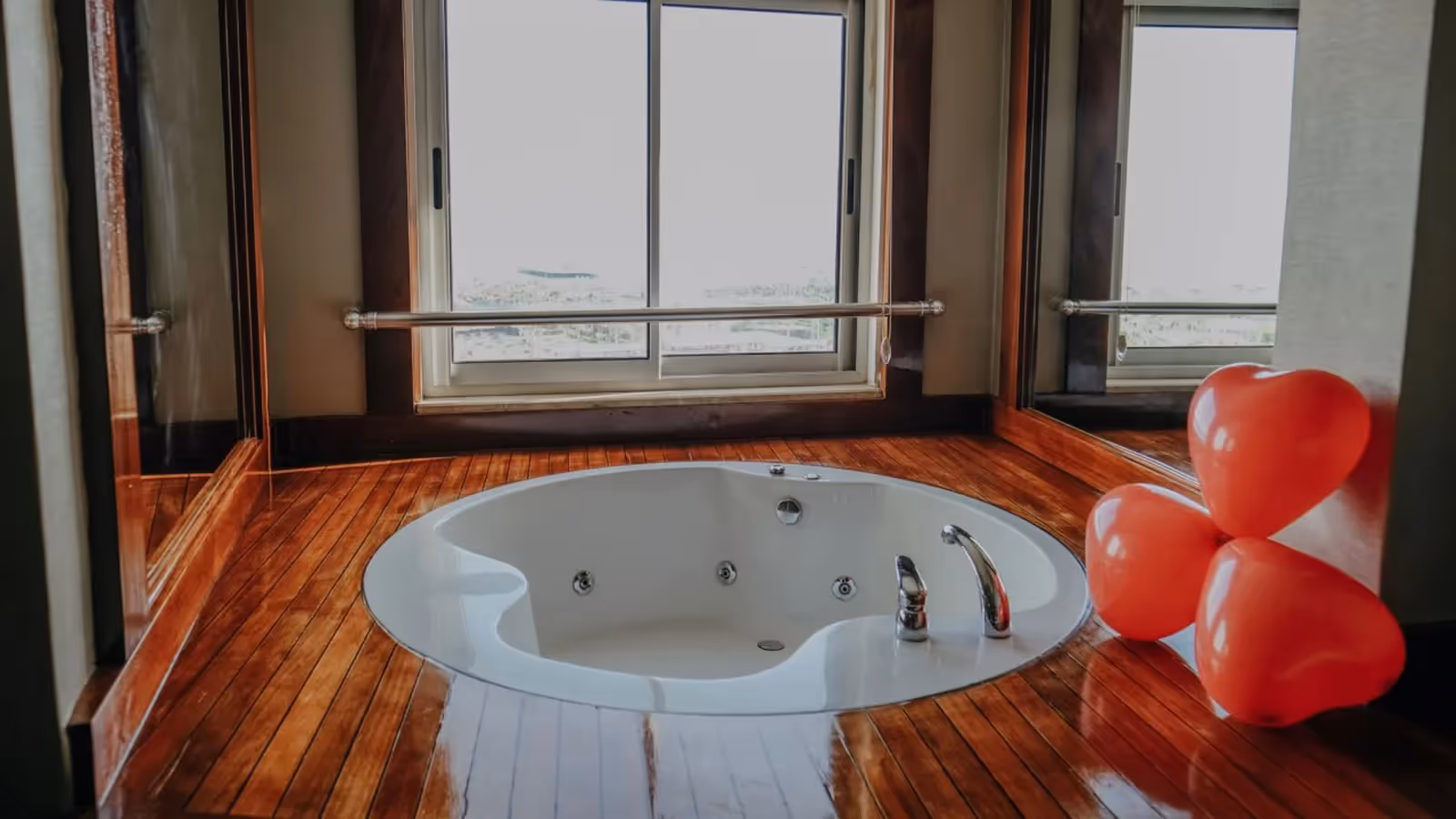 Ronde whirlpool in een houten verhoging voor een groot raam in Saturn Palace Resort in Lara