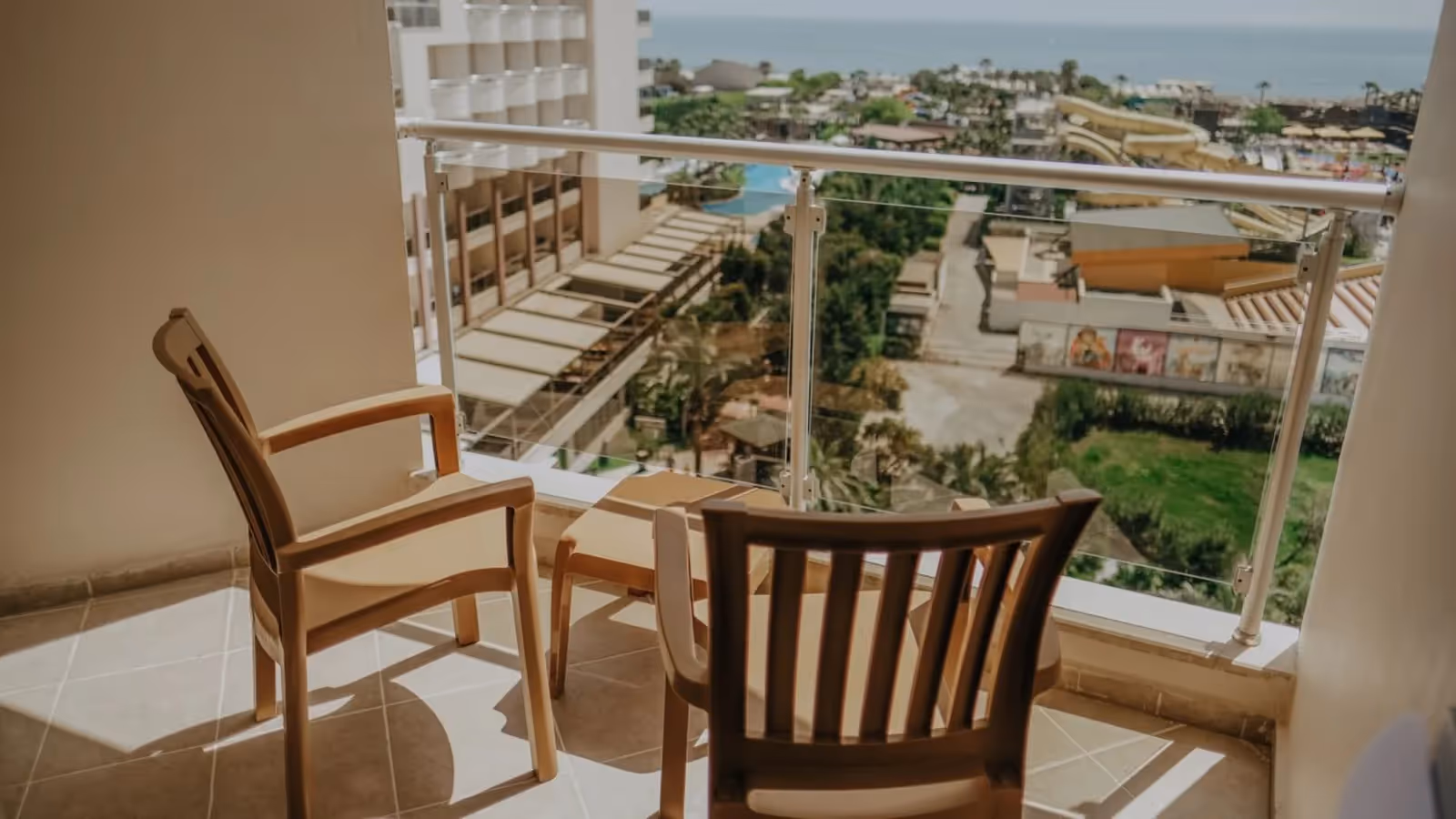 Balkon met houten stoelen en uitzicht over de tuin richting zee bij Saturn Palace Resort in Lara