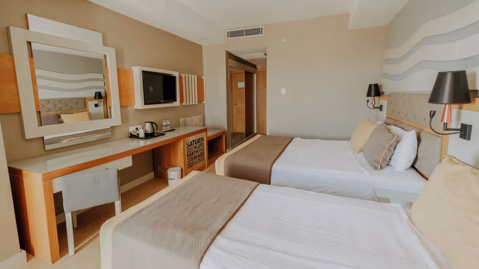 Kamer met twee bedden, een bureau met spiegel en een tv aan de wand in Saturn Palace Resort in Lara