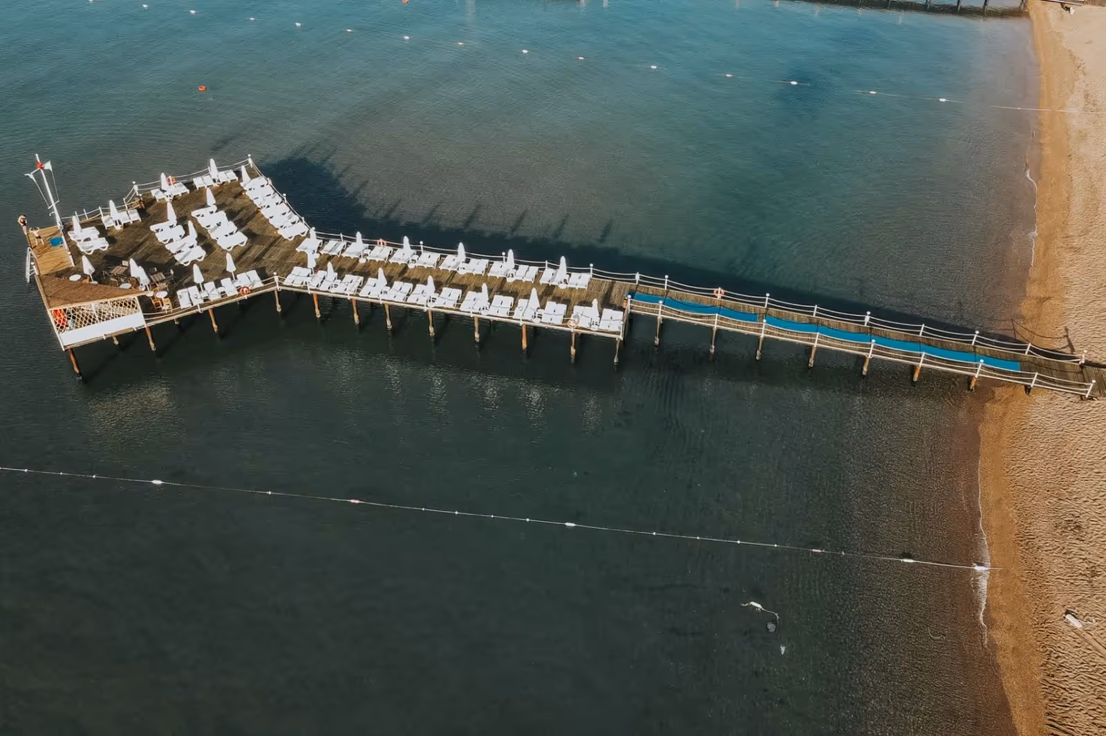 Luchtfoto recht van boven op de lange pier met het ligplatform in zee bij Saturn Palace Resort in Lara
