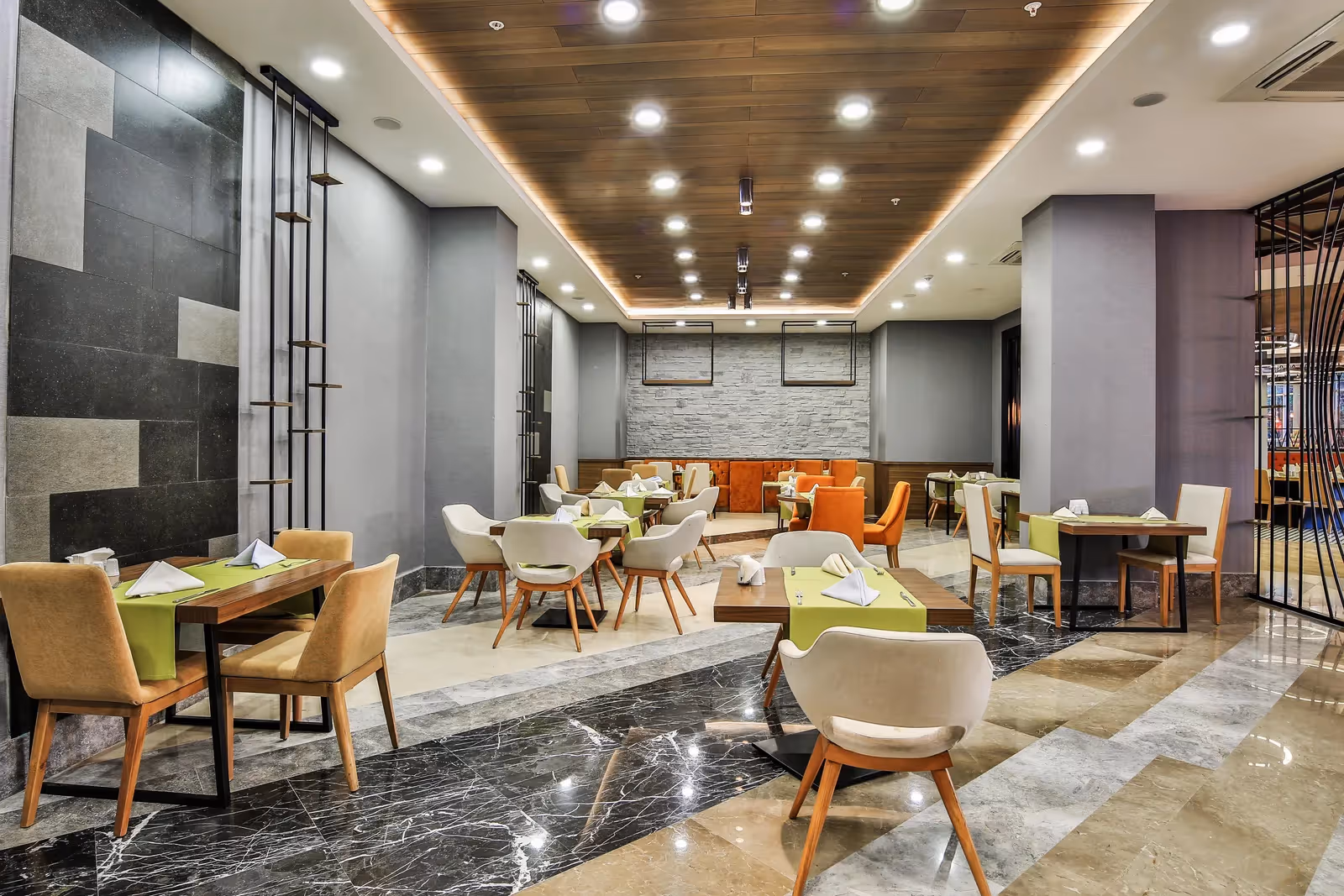 Restaurant met grijze wanden, houten tafels en witte stoelen in Saturn Palace Resort in Lara