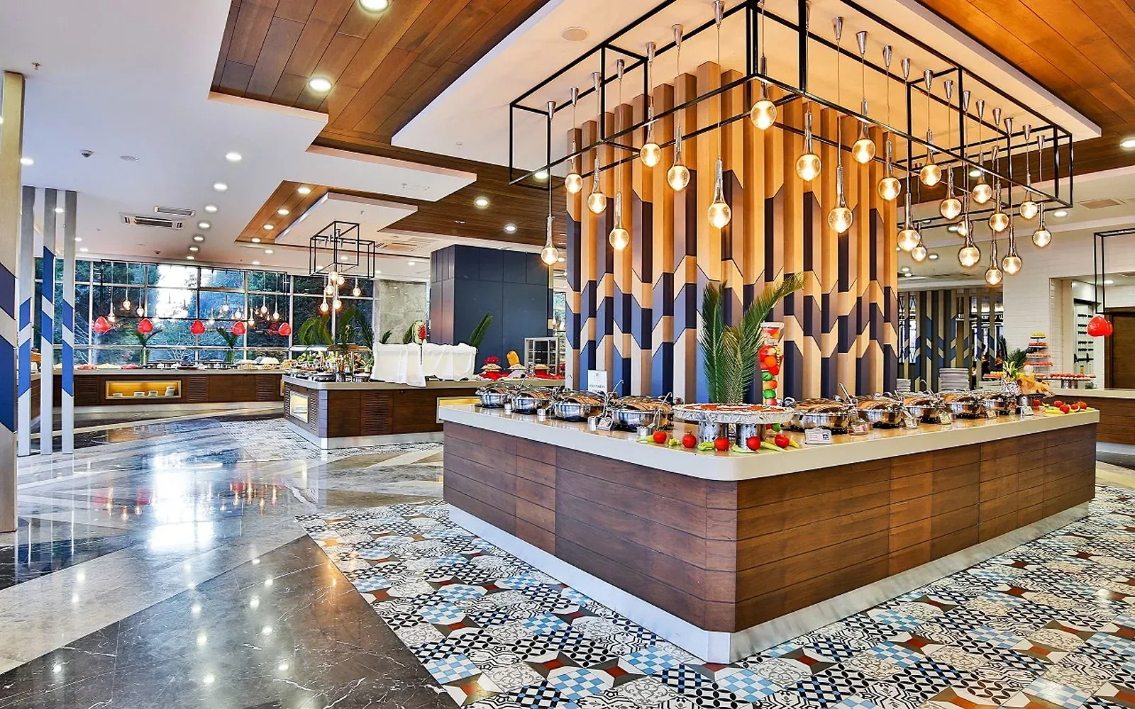 Buffetrestaurant van Saturn Palace Resort met een houten buffeteiland, hanglampen en een tegelvloer met patroon