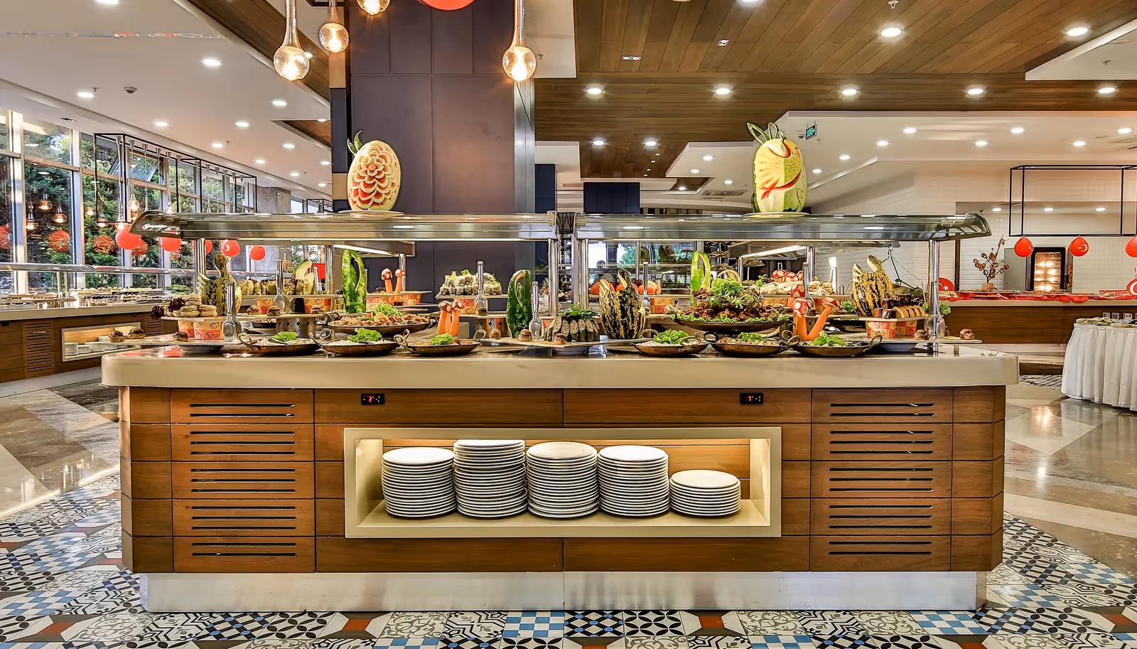 Buffet met salades en een stapel borden in het hoofdrestaurant in Saturn Palace Resort in Lara