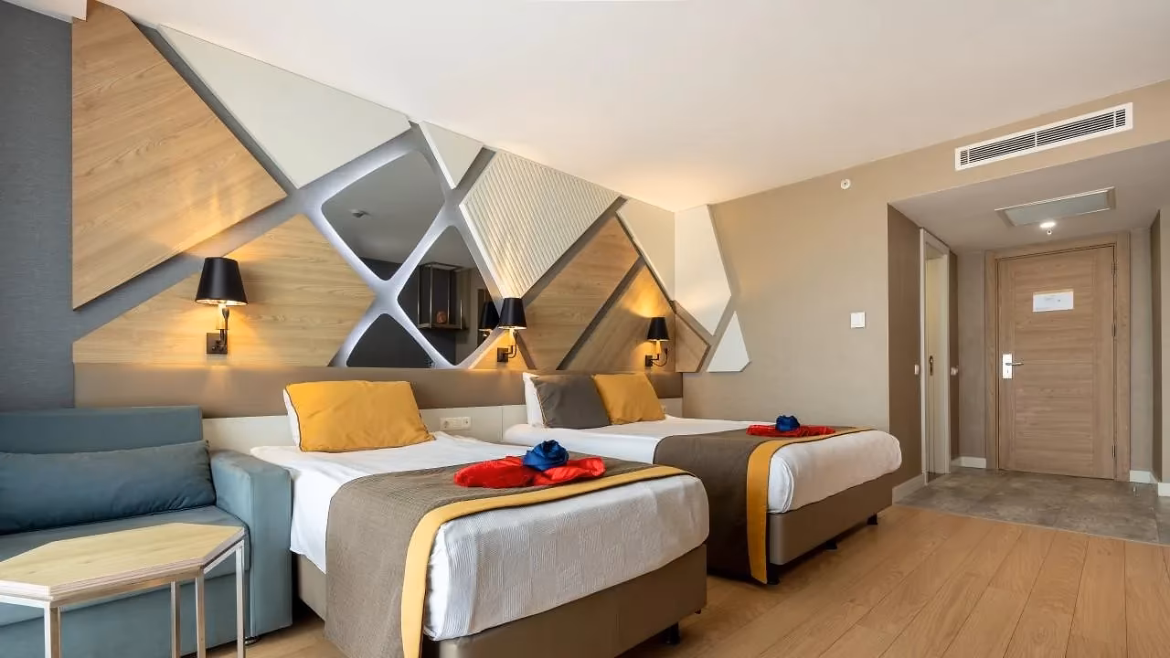 Kamer met twee bedden, een bank en een wand met witte en houten panelen in Saturn Palace Resort