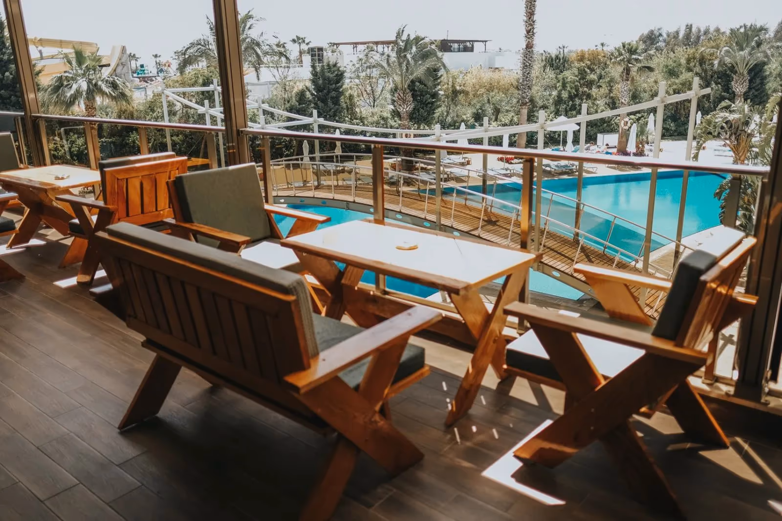 Houten terras met tafels en stoelen aan het zwembad bij Saturn Palace Resort in Lara