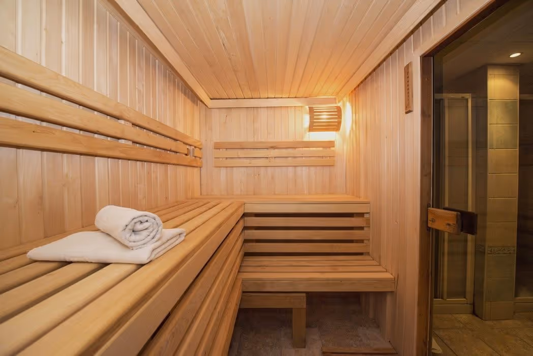 Houten sauna met banken en een opgerolde handdoek in Saturn Palace Resort in Lara