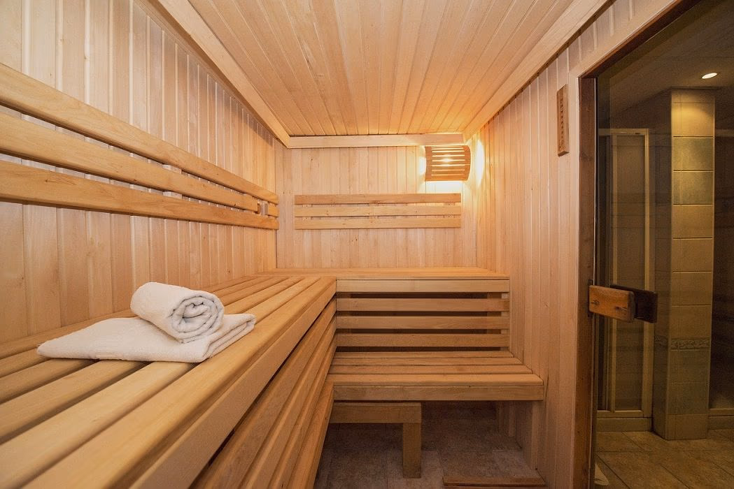 Houten sauna met banken en een opgerolde handdoek in Saturn Palace Resort